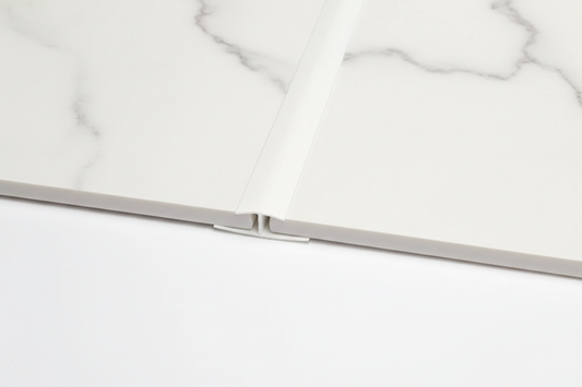 H Trim joining two white marble panels